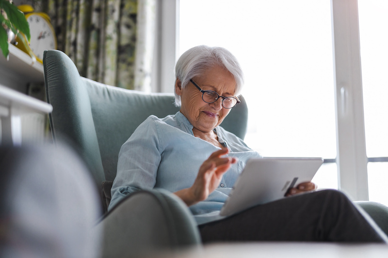 old woman sitting in chair reading