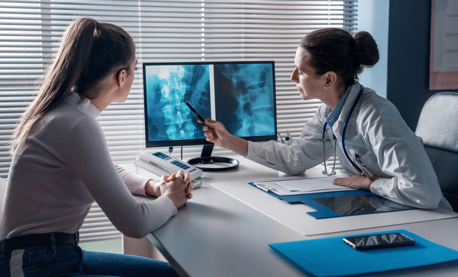 doctor and patient examining spine xrays