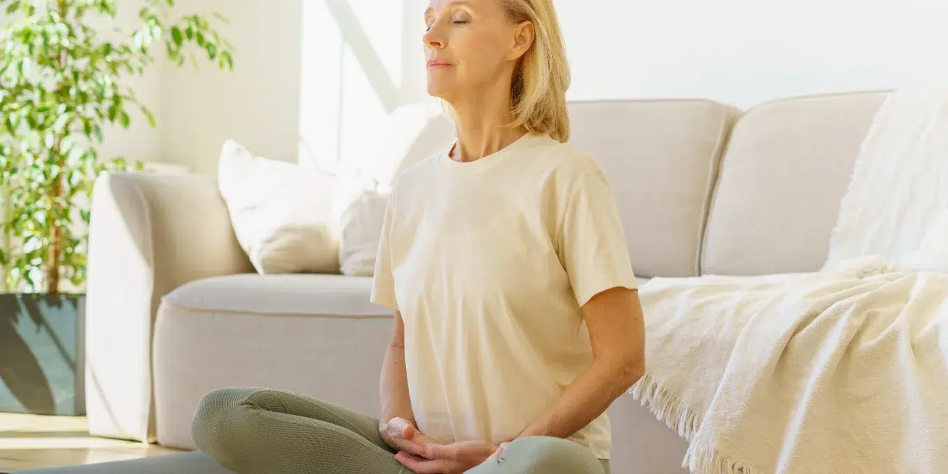 woman in lotus position meditation with closed eyes at home